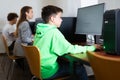 Schoolboy using computer at lesson, teacher teaching pupils in class room Royalty Free Stock Photo