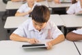 Schoolboy using digital tablet in classroom