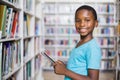 Schoolboy using digital tablet in library Royalty Free Stock Photo