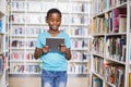 Schoolboy using digital tablet in library Royalty Free Stock Photo