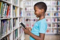 Schoolboy using digital tablet in library Royalty Free Stock Photo