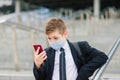 Schoolboy walks out of school wearing protective mask in a city