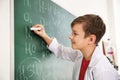 Schoolboy writing chemical formulas on chalkboard Royalty Free Stock Photo