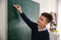 Schoolboy writing chemical formulas on chalkboard Royalty Free Stock Photo