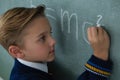 Schoolboy writing maths formula on chalkboard Royalty Free Stock Photo