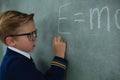 Schoolboy writing maths formula on chalkboard Royalty Free Stock Photo