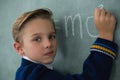 Schoolboy writing maths formula on chalkboard Royalty Free Stock Photo