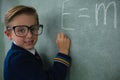 Schoolboy writing maths formula on chalkboard Royalty Free Stock Photo