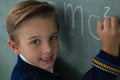 Schoolboy writing maths formula on chalkboard Royalty Free Stock Photo