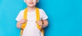 Schoolboy with yellow backpack against blue background Royalty Free Stock Photo