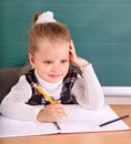 Schoolchild in classroom near blackboard.