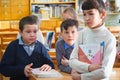 Schoolchildren with books in the classroom near the Desk