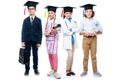 schoolchildren in costumes of different professions and graduation caps looking at camera