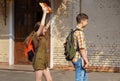 Schoolchildren are having fun in the school yard - a teenage girl wants to hit a boy on the head with books Royalty Free Stock Photo