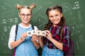 schoolchildren holding wooden cubes with word math near blackboard