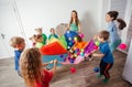 Schoolchildren playing using parachute with friends in gym