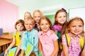 Schoolchildren sitting close near desk and smile Royalty Free Stock Photo