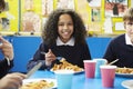 Schoolchildren Sitting At Table Eating Cooked Lunch Royalty Free Stock Photo