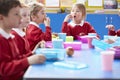 Schoolchildren Sitting At Table Eating Packed Lunch Royalty Free Stock Photo