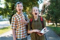 schoolchildren, a teenage boy and a girl are yawning, tired of studying and want to sleep, a city street on a summer day Royalty Free Stock Photo