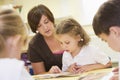 Schoolchildren and their teacher reading in class Royalty Free Stock Photo