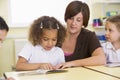 Schoolchildren and their teacher reading in class Royalty Free Stock Photo