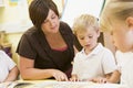 Schoolchildren and their teacher reading in class Royalty Free Stock Photo