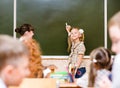 Schoolgirl answers questions of teachers near a school board Royalty Free Stock Photo