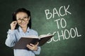 Schoolgirl with back to school word on chalkboard Royalty Free Stock Photo