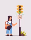 schoolgirl with backpack waiting for green traffic light to cross road on crosswalk road safety concept
