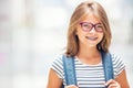 Schoolgirl with bag, backpack. Portrait of modern happy teen school girl with bag backpack. Girl with dental braces and glasses Royalty Free Stock Photo