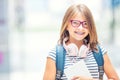 Schoolgirl with bag, backpack. Portrait of modern happy teen school girl with bag backpack headphones and tablet. Royalty Free Stock Photo