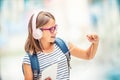 Schoolgirl with bag, backpack. Portrait of modern happy teen school girl with bag backpack headphones and tablet. Royalty Free Stock Photo