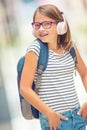 Schoolgirl with bag, backpack. Portrait of modern happy teen school girl with bag backpack headphones and tablet. Royalty Free Stock Photo