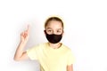 A schoolgirl in a black protective mask draws attention to the correctness and compulsory wearing of protective masks.