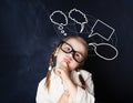 Schoolgirl at blackboard in classroom and speech cloud