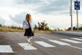 schoolgirl crosses the road at a pedestrian crossing Royalty Free Stock Photo