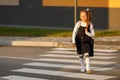 schoolgirl crosses the road at a pedestrian crossing Royalty Free Stock Photo