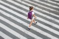 Schoolgirl crossing road on way to school. Zebra traffic walk way in the city. Concept pedestrians passing a crosswalk.  Stylish Royalty Free Stock Photo