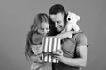 Schoolgirl and dad hold present box and teddy bear. Royalty Free Stock Photo