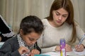 Schoolgirl at a desk with a woman teacher