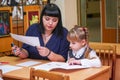 Schoolgirl at a desk with a woman teacher