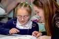 Schoolgirl at a desk with a woman teacher