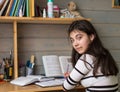 Schoolgirl does his homework, looking at the camera. Education. Royalty Free Stock Photo