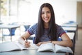 Schoolgirl doing homework in classroom Royalty Free Stock Photo