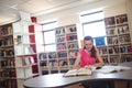 Schoolgirl doing homework in in library at school Royalty Free Stock Photo