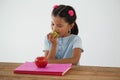 Schoolgirl eating apple against white background