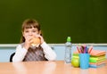 Schoolgirl eating fast food during lunch break