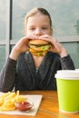 Schoolgirl eating fast food at a table in a restaurant