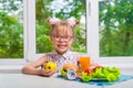 Healthy school lunch: apple, juice, hamburger, vegetables, lettuce. The child is smiling